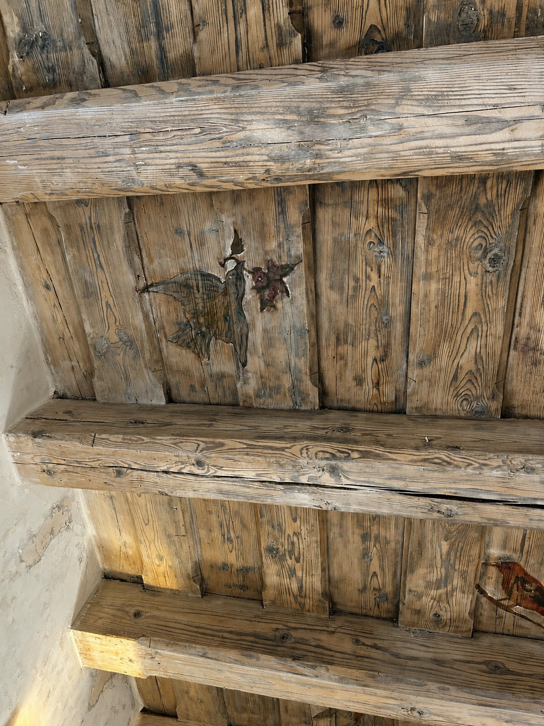 Original painted decoration preserved on a timber plank ceiling