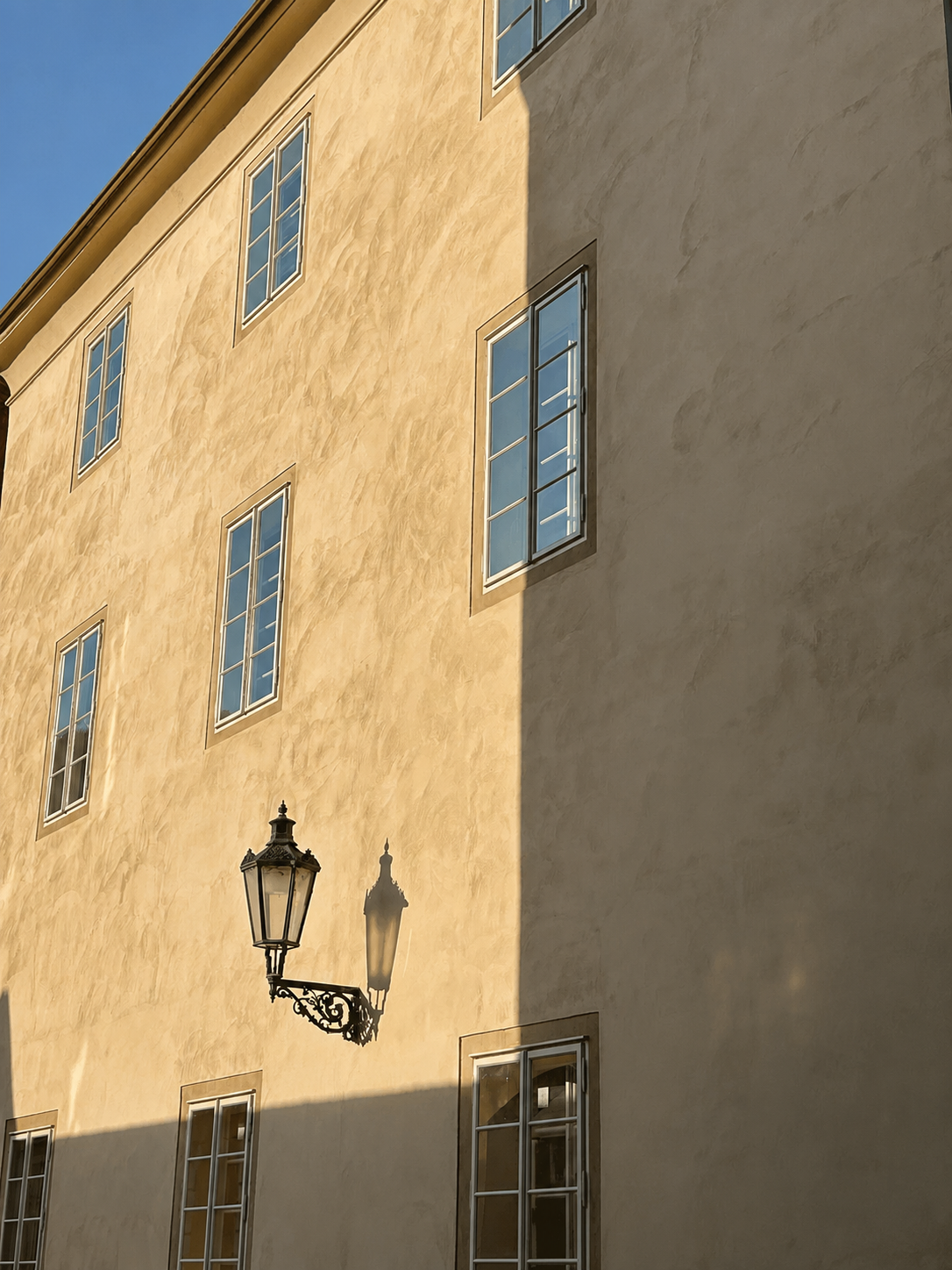 Late light on the warm plaster façade with a wrought iron lantern